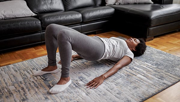 Woman practicing yoga, Glute Bridge exercise, dvi pada pithasana pose