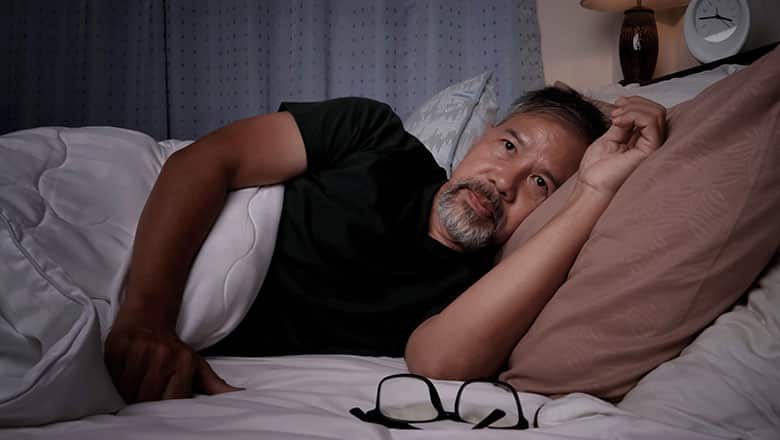 depressed old man and stressed lying in bed from insomnia