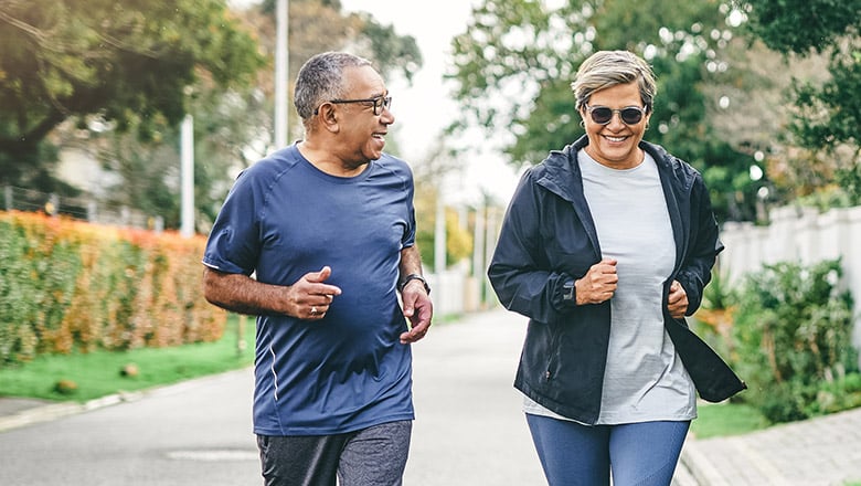 Two adults on a fast-paced walk through their neighborhood.